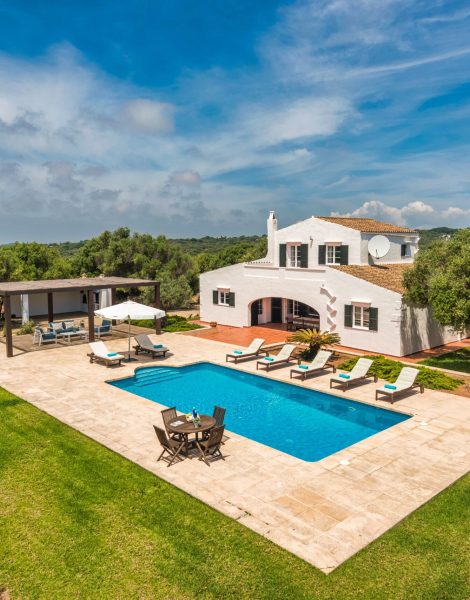 Foto desde altura de casa blanca de estilo mediterraneo con jardín, psicina y zona de hamacas